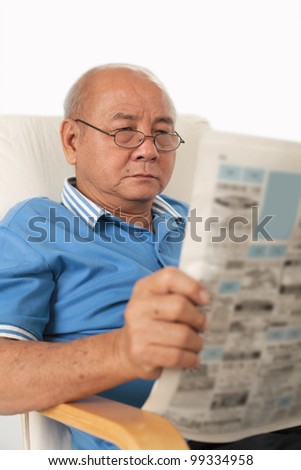 Asian senior man reading newspaper on white background