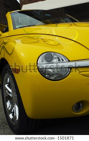 Headlight on a tricked out yellow sports car.