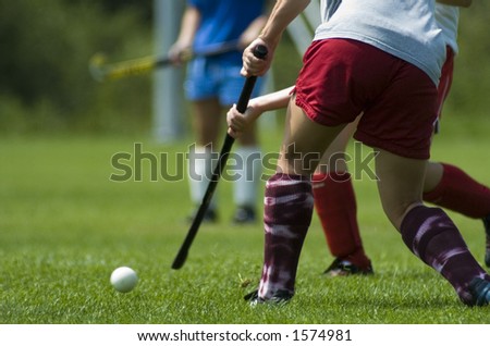A girl hits a field hockey ball