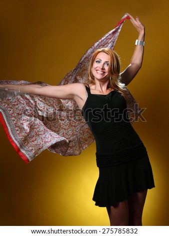 beautiful young woman with a scarf in the wind . on a yellow background. active model