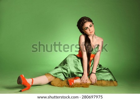 active model on a green background . stylish hairstyle, make-up art, studio photos, interesting image