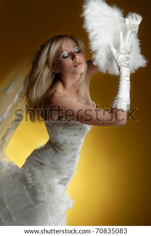 portrait of a bride with a fan on a yellow background