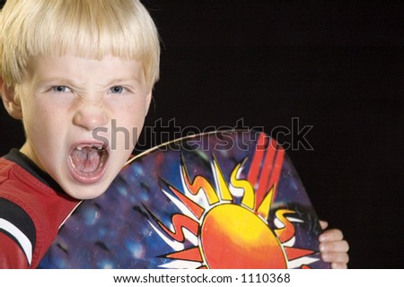 A toothless youth roars while holding a boogie board.