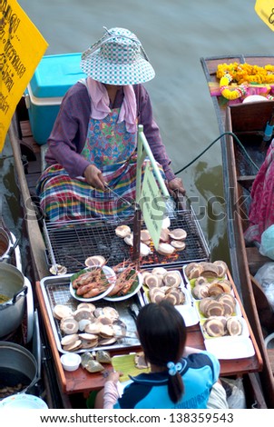 SAMUTSONGKRAM,THAILAND-SEPT 6 : Local vendor selling food at Amphawa evening floating Market famous floating market and cultural tourist destination on September  6, 2012 in Samutsongkram, Thailand.