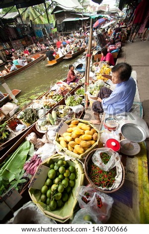 RATCHABURI,THAILAND -JUL 21:Local merchant sell food ,fruits and product at Damnoen Saduak floating market,on July 21,2013 in Ratchaburi,Thailand .Dumnoen Saduak is a very popular tourist attraction.
