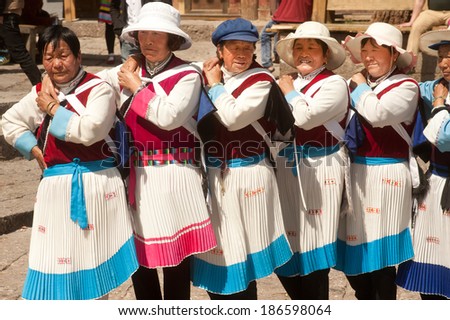 LIJIANG,CHINA-MARCH 17: A group of Naxi nationality old woman dressed in national clothing dancing.Located in Lijiang Dayan Old Town Square street (Sifang Street) on March 17,2014,Yunnan in China.