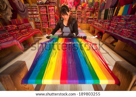 LIJIANG,CHINA Ã¢Â?Â? MARCH 17: Naxi women weaving brightly colored Show of visitors and sales wholehearted in Lijiang is the largest ancient old town on March 17, 2014, Yunnan in Southwestern of China.