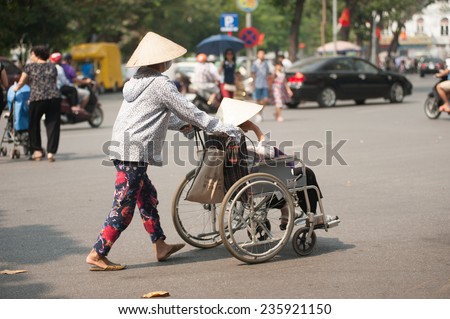 HANOI,VIETNAM - OCTOBER 12 : Vietnamese patient with a wheelchair for exercise and relax common in the street on October 12,2014 in Hanoi city,Vietnam.