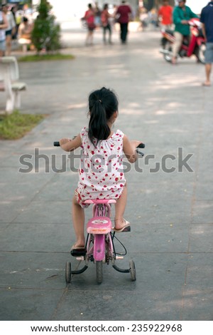 HANOI,VIETNAM - OCTOBER 12 : Young girl Vietnamese riding bicycle in the morning for exercise and relax common in the street park on October 12,2014 in Hanoi city,Vietnam.