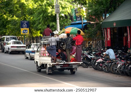 MANDALAY,MYANMAR - JULY 2 : unidentified Burmese peoples in a truck on July 2, 2014 in Mandalay city, Middle of Myanmar. Truck is a popular transportation in Myanmar because it can carry many people.