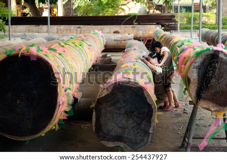 ANGTHONG,THAILAND-JAN 8 : People write their own name on the ancient Iron Wood timber.With the belief that it will bring good luck in Wat Chaiyo Worawihan temple on January 8,2014, Angthong ,Thailand.