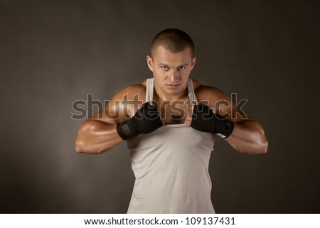 Young Boxer fighter over black, shirt rip to shreds