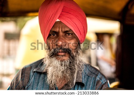 AGRA, INDIA - APRIL 12: Unidentified man who dress indian tradition cloth hat and drive  public car transportation that\'s call \'auto rickshaw\' on Apr 12, 2014 in Agra, India.