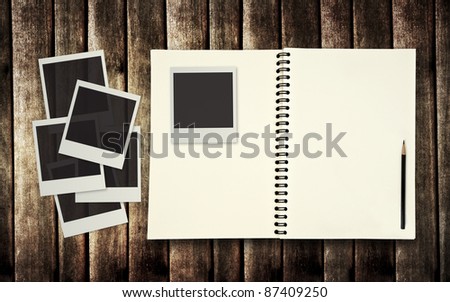 blank book with photo frame on old wooden background
