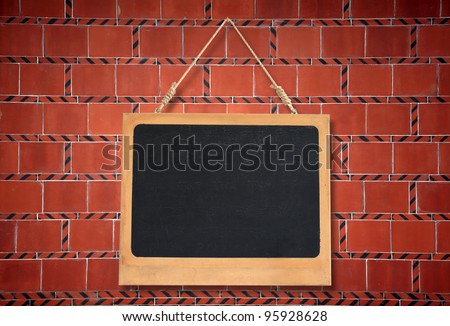 blank chalkboard hanging on brick wall