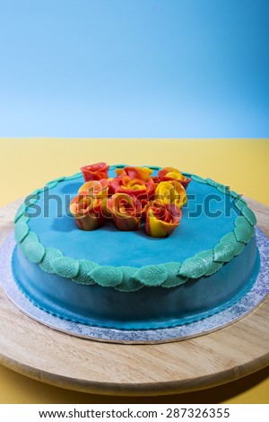Blue layer cake on a serving plate with edible roses