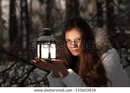 beautiful girl on winter forest with lantern