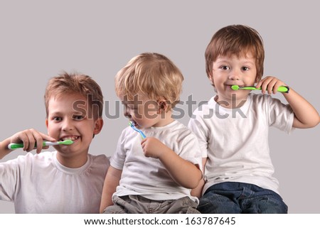 three brothers brushing teeth together