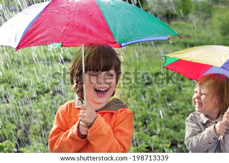 two happy brother with umbrella outdoors
