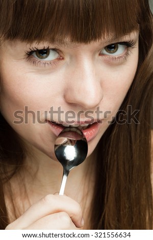 beautiful girl with a spoon in his mouth