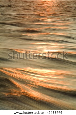 Sunset topped waves purposely photographed to capture the motion blur from aboard a moving boat.
