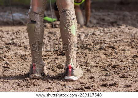 woman legs with dirty socks with mud on extreme run