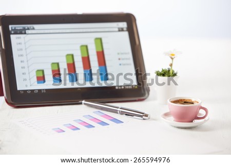 working in a graph bar with tablet and a cup of coffee