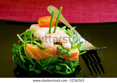 fresh salmon tartar on black platter with rocket salad