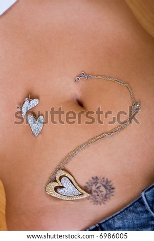 a piece of jewellery with hearts rings over skin and sun tattoo