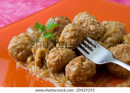 orange decorated platter with meat balls on onions sauce