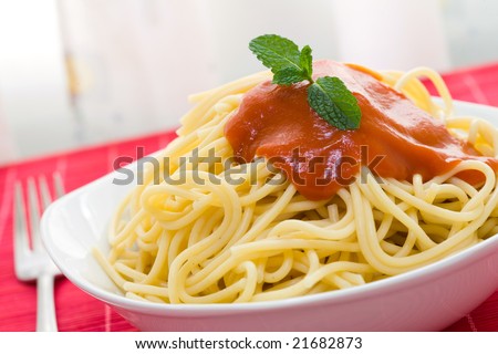 spaghetti with tomato sauce on white bowl and fork