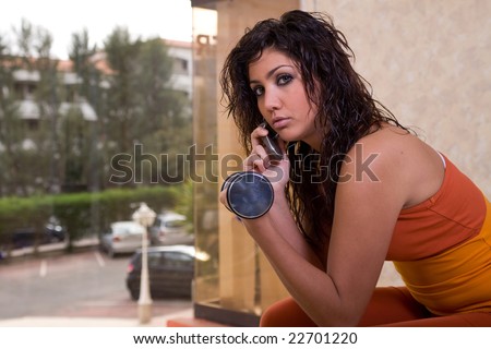 young latin sport woman with silver dumbbells talking with phone