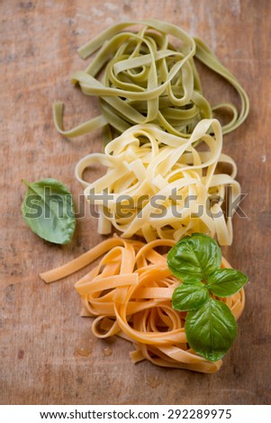 Close-up of italian tricolor pasta with basil, view from above