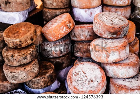 Different sorts of Spanish cheese wheels at a market  ( HDR image )