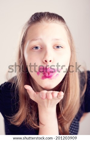 Happy teen girl sending air kiss
