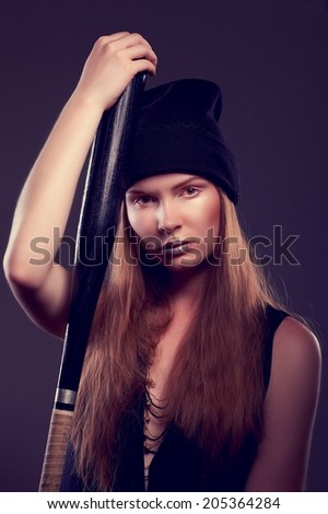 Cool hot fashionable woman bandit dressed in hat with baseball bat