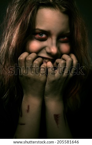 Close up portrait of evil scary girl possessed by a demon with a sinister smile
