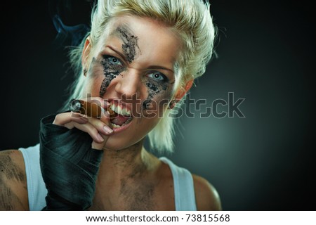 Closeup portrait of a beautiful young caucasian punk woman with dirty face and cigar in her mouth