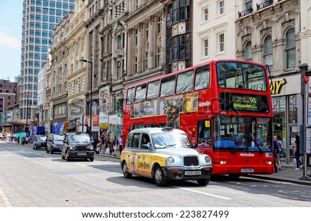 LONDON - JULY 1, 2014: Double-decker red bus and a black cab at a bus stop on Oxford street in London near Tottenham Court Road Station and Central Point.