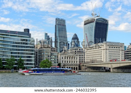 LONDON, UNITED KINGDOM - JULY 1, 2014: A City Cruises tour boat sails on the Thames River near London Bridge. Thames is the longest river in England with 346 km (215 miles) long.