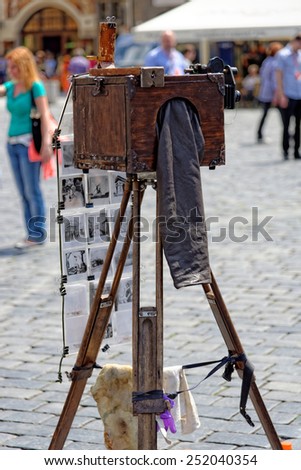 PRAGUE, CZECH REPUBLIC - JULY 3, 2014: Tourists are invited to take a picture by antique camera in the Old town square. Various artists show and sell their works at tourist hot spots in Prague.