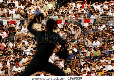 A major league baseball pitcher throws with a sunlit crowd behind him at Petco Park in San Diego.