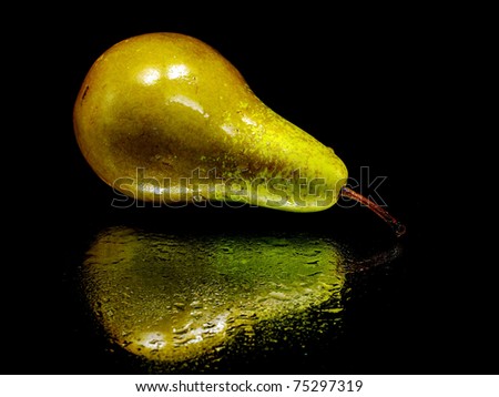 Brown pear on a black background with water drops