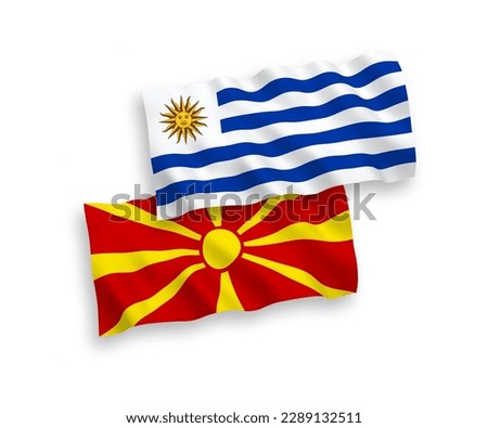 National vector fabric wave flags of Oriental Republic of Uruguay and North Macedonia isolated on white background. 1 to 2 proportion.