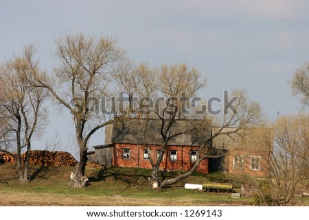 The house in a field among trees. Village
