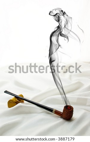 Wooden pipe on satin with drifting smoke in the shape of a beautiful woman.