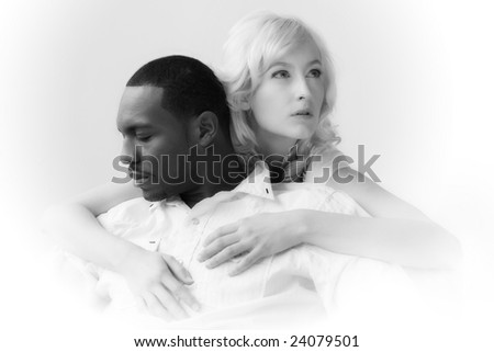 African American man and Caucasian woman holding each other. Naturally lit, high-key image on white background.