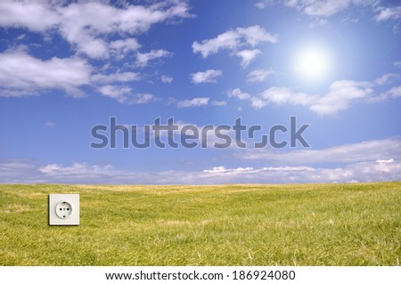 Creative use of lens flare for Green energy concept with landscape wallpaper and electric outlet
