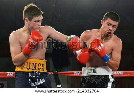 GLENDALE, CA - AUGUST 9, 2014: Boxer Liam Vaughn follows through on a punch which leaves his opponent Saul Benitez grimacing. The bout took place in Glendale, California on August 9, 2014.