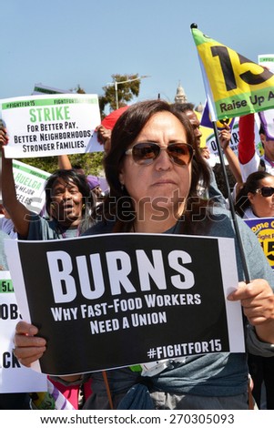 LOS ANGELES, CA   APRIL 15, 2015: Protestors hold signs advocating raising the minimum wage for fast food workers during a demonstration in Los Angeles on April 15, 2015.